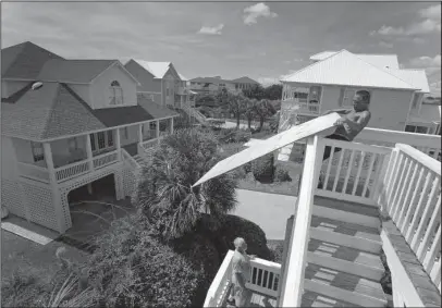  ?? The Associated Press ?? BOARDING UP: Tim Avery, right, and Willie Avery pull boards to the third story as they prepare for Hurricane Florence on Wednesday at a home in Emerald Isle N.C.