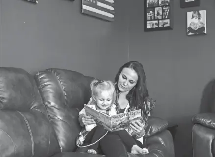  ?? PHOTOS BY JOSHUA A. BICKEL/ COLUMBUS DISPATCH ?? Haley Allgood and her daughter, Novalee, 2, read “The Little Engine that Could” at their home in Leesburg in Highland County.