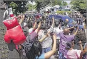  ?? ALTON STRUPP/THE COURIER-JOURNAL VIA USA TODAY NETWORK ?? A pair of boxing gloves hangs on a marker as the funeral procession for boxing great Muhammad Ali makes its way past his boyhood home in Louisville, Ky., on Friday.