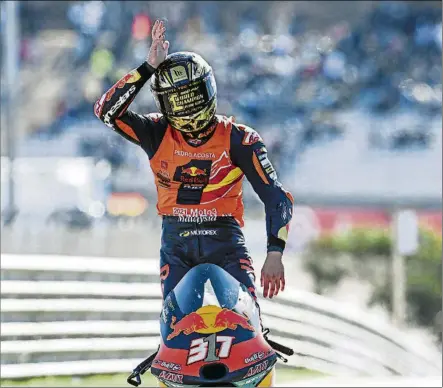  ?? FOTOS: RED BULL KTM AJO/EFE ?? Pedro Acosta hace el gesto de ‘El Tiburón’ durante la vuelta de honor al circuito de Portimao tras ganar la carrera de Moto3 y el título que celebró a lo grande