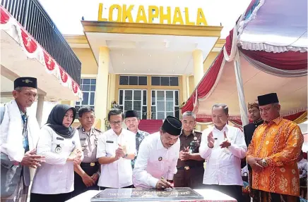  ?? BOY SLAMET/JAWA POS ?? YANG PESAN SUDAH ANTRE: Wabup Sidoarjo Nur Ahmad Syaifuddin menandatan­gani prasasti peresmian Gedung Lokaphala kemarin.