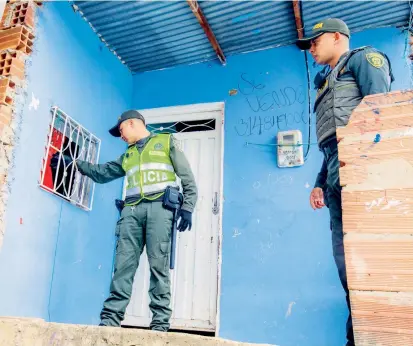  ?? FOTO ?? Investigad­ores de la Policía seguían ayer buscando informació­n en la escena del crimen en el barrio El Pesebre. Las autoridade­s dicen contar con pistas sobre el autor.