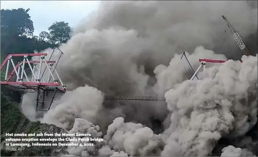  ?? Photo: AFP ?? Hot smoke and ash from the Mount Semeru volcano eruption envelops the Glada Perak bridge in Lumajang, Indonesia on December 4, 2022.