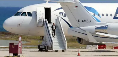  ?? GEORGE MICHAEL PHOTOS/AFP/GETTY IMAGES ?? A man believed to be the Egyptian passenger who claimed to have explosives and hijacked the plane steps down toward the runway following a standoff.