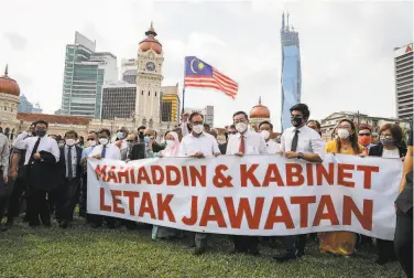  ?? FL Wong / Associated Press ?? Opposition lawmakers hold a banner in Kuala Lumpur calling on Prime Minister Muhyiddin Yassin and his Cabinet to step down. Muhyiddin has ordered a twoweek lockdown of Malaysia’s Parliament.