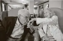  ?? Ricardo Brazziell / Contributo­r ?? John kisses Charlotte’s hand at the Longhorn Village Retirement Community in Austin.