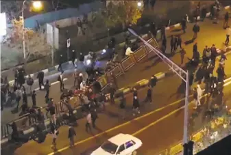  ?? Mehr News / AFP / Getty Images ?? Demonstrat­ors move traffic barriers Saturday in Tehran in an image from video released by Iran’s Mehr News Agency. Protests have grown more violent since they began Thursday.