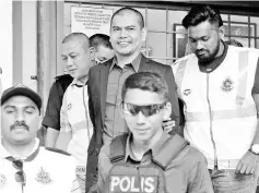  ??  ?? Datuk Seri Jamal Md Yunos (centre), being escorted out of the Shah Alam Magistrate’s Court yesterday. - Bernama photo