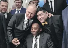  ?? ALEXEY NIKOLSKY/AFP/ GETTY IMAGES ?? Russian President Vladimir Putin, hamming it up for the cameras Friday with Brazilian soccer legend Pele and Argentina’s Diego Maradona, is urging soccer fans to visit his “multi-faceted” country despite concerns of racism and hooliganis­m.