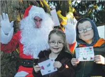  ?? 16_T47_winterfest­ival27 ?? Callum and Ellie McGuckin from Dunbeg give Santa their Christmas letters at Dunollie.