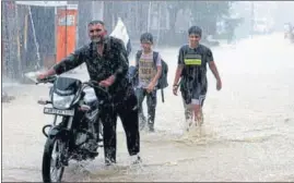  ?? MANOJ DHAKA /HT ?? Commuters make their way through a waterlogge­d road in Rohtak on Thursday.