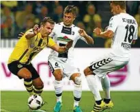  ?? Foto: Thilo Schmülgen, Reuters ?? Dortmunds Mario Götze (l.) im Zweikampf mit Freiburgs Amir Abrashi und Nils Petersen.