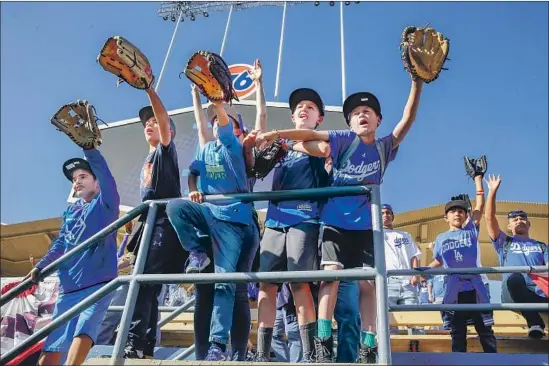  ?? Robert Gauthier Los Angeles Times ?? YOUNG FANS HOPE for a ball during batting practice at Dodger Stadium, where attendance has stayed at near-record levels while ticket prices continue to soar.