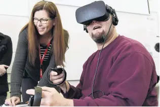  ?? PHOTOS: GERARD O’BRIEN ?? Animation Research chief executive Cheryl Adams shows an Otago Correction­s Facility inmate the new virtual reality simulation, designed to teach automotive engineerin­g skills.