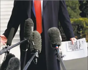  ?? Joshua Lott / AFP via Getty Images ?? President Donald Trump reads from his notes as he talks to the media on the South Lawn of the White House before boarding Marine One in Washington on Wednesday, en route to Austin, Texas.