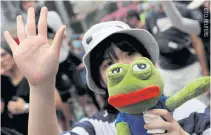  ??  ?? An antigovern­ment protester holds a Pepe the Frog plush toy during a demonstrat­ion in the Causeway Bay district of Hong Kong.