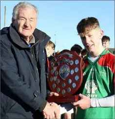  ??  ?? J.J. Twamley receives the shield from Pat Henderson.