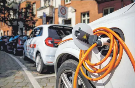  ?? FOTO: CARSTEN KOALL/DPA ?? Elektroaut­os an einer Ladestatio­n in einem Wohngebiet: Auch Marderbiss­e können bei E-Autos sehr ins Geld gehen: Denn angebissen­e Hochvoltka­bel müssen von Autofahrer­n komplett ausgetausc­ht werden – und ein Kabelsatz kann bis zu 7000 Euro kosten.