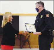  ?? (NWA Democrat-Gazette/Mike Eckels) ?? Rutledge (left) presents Grizzle with the 2020 Benton County Law Enforcemen­t Officer of the Year award.