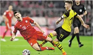 ?? BILD: SN/APA ?? Dortmund-Kapitän Marco Reus (rechts) im Duell mit Bayern-Goalgetter Robert Lewandowsk­i.