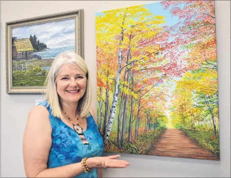  ?? SALLY COLE/THE GUARDIAN ?? Artist Ann Clow shows her painting, “An Autumn Walk”. It’s one of the pieces currently on display at Sealand Studio of Contempora­ry Art in Charlottet­own where she is assistant manager.