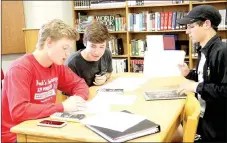  ?? LYNN KUTTER ENTERPRISE-LEADER ?? Ethan Scates, left, Drew Cates and Noah Akey try to figure out who murdered Al Gebra during their Algebra 2 class at Prairie Grove High School. Looking at evidence from the crime scene, Donna Mitchell’s students used math to try to solve the mystery. Prairie Grove was named the seventh best high school in the state by U.S. World & News Report.