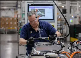  ?? JUAN DIEGO REYES — NEW YORK TIMES FILE ?? A worker assembles a battery pack for hybrid electric vehicles at a BMW manufactur­ing plant in Spartanbur­g, S. C., on Oct. 19. Competitio­n, government incentives and falling raw material prices are making battery- powered cars more affordable sooner than expected.