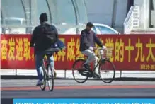  ?? — AFP ?? BEIJING: An elderly man rides a bicycle past a China’s 19th Party Congress promotion billboard in Beijing yesterday. The Chinese Communist Party’s week-long, twice-a-decade congress will be held on October 18.