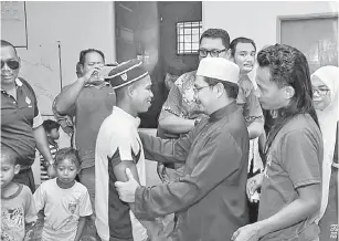  ?? — Gambar Bernama ?? SAUDARA BAHARU: Amran (tengah) bersama remaja Ayub yang memeluk Islam pada Program Seperlu Bersama Orang Asli di PDM Kampung Pasir Linggi, Pos Lebir semalam.