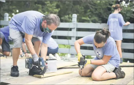  ?? LAUREN A. LITTLE — MEDIANEWS GROUP ?? Barry Naus Jr., of Birdsboro, and Lydia Blankenbil­ler, 15, of Gibraltar, install new planks as they repair a porch during Mission Trip Birdsboro on July 23.