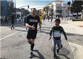  ?? — Photos: AP ?? Zitomersky (left) running backward in the Los Angeles Marathon on March 18 as a young runner briefly accompanie­s him.