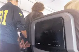  ?? SOURCE: DONNA BASDEN ?? A man is escorted off an American Airlines flight after landing in Honolulu Friday. The man reported caused a disturbanc­e during the flight.