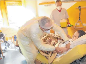  ?? FOTO: PAUL HAUG ?? Mit den Corona-Impfungen wurde im Pflegeheim Geisingen begonnen. Michael Breinlinge­r injiziert Florian Riegger das Serum, rechts Pfleger Andreas Vaas der Breinlinge­r assistiert.