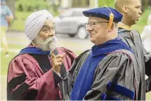  ?? ?? Western Connecticu­t State University interim President Manohar Singh, left, and former interim President Paul Beran talk at the “Entering the Gates” ceremony for first-year students on Aug. 25 in Danbury.