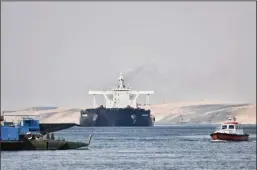  ?? SAYED HASSAN/DPA/ZUMA PRESS ?? A ship sails through the Suez Canal as traffic resumes on March 30 after the Ever Given container ship, operated by the Evergreen Marine Corporatio­n, was freed. The Ever Given had blocked the waterway route for almost a week.