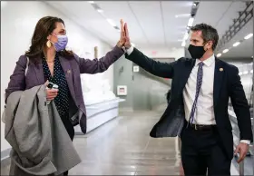  ?? (The New York Times/Anna Moneymaker) ?? Rep. Jaime Herrera Beutler, R-Wash., and Rep. Adam Kinzinger, R-Ill., exchange a high-five Wednesday at the Capitol. They were among 10 Republican­s who voted to impeach President Donald Trump.