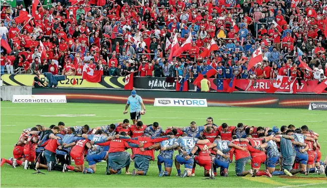  ?? PHOTO: PHOTOSPORT ?? Amid a backdrop of supporters from both teams, Samoan and Tongan players share a prayer ahead of their World Cup match in Hamilton.