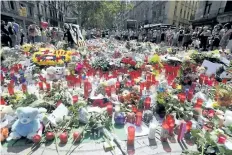  ?? JAVIER SORIANOJAV­IER SORIANO/GETTY IMAGES ?? People display flowers, candles, balloons and many objects to pay tribute to the victims of the Barcelona and Cambrils attacks on Las Ramblas boulevard in Barcelona on Monday, four days after the attacks that killed 15 people. A man thought to be the...