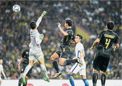  ??  ?? Horror show: Malaysia goalkeeper Mohamed Haziq Nadzli punching the ball into his own net as the Thai players celebrate (top) during the final at the Shah Alam Stadium yesterday.