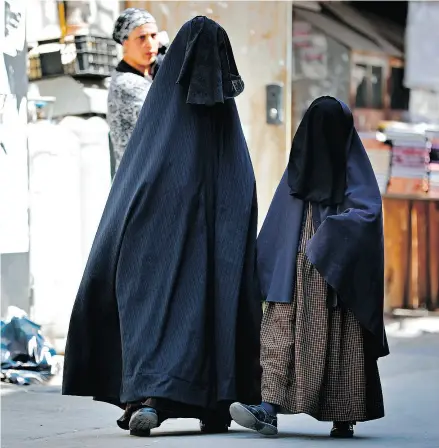  ?? THOMAS COEX / AFP / GETTY IMAGES FILES ?? An ultra- Orthodox Jewish woman and her daughter walk in Jerusalem wearing the Jewish equivalent of a burka called a frumqa. They are sometimes called the Taliban women, Barbara Kay writes.