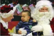  ?? MARK THIESSEN — THE ASSOCIATED PRESS ?? This photo shows Nate Pete sitting on Santa Claus’ lap in Saint Michael, Alaska, a remote island community off the state’s western coast in the Bering Strait.