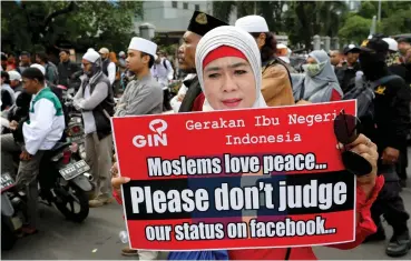  ??  ?? A Muslim woman holds a poster during a rally outside the Facebook office in Jakarta. Muslim hardliners claim the social media giant blocked multiple pages and accounts related to their group.