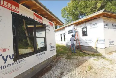  ?? NWA Democrat-Gazette/FLIP PUTTHOFF ?? Charles Proctor (left) and Cory Nichols work Aug. 24 on a home at The 81 in downtown Rogers.