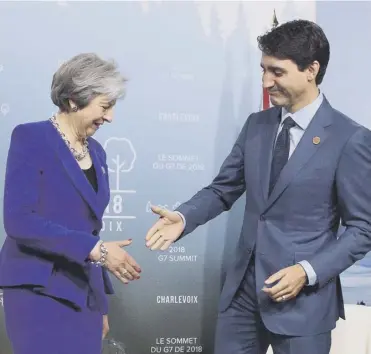  ??  ?? r Theresa May is greeted by Canadian Prime Minister on the first day of the G7 Summit