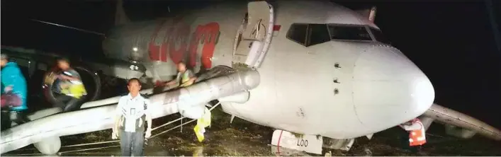  ?? FRANCO/GORONTALO POST ?? TIDAK ADA KORBAN: Penumpang pesawat Lion Air JT 892 keluar melalui pintu darurat setelah pesawat tergelinci­r di Bandara Djalaluddi­n kemarin.
