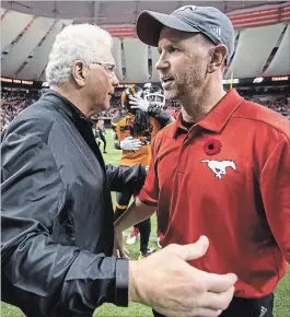  ?? DARRYL DYCK THE CANADIAN PRESS ?? B.C. Lions head coach Wally Buono, left, and Calgary Stampeders head coach Dave Dickenson meet at centre field after Buono coached his last regular-season Canadian Football League game in Vancouver on Saturday. Calgary won, 26-9.