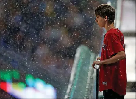  ?? MATT STONE/BOSTON HERALD ?? A young fan watches as the rain starts during the fifth inning of the MLB game against the Miami Marlins at Fenway Park on Wednesday in Boston, MA.