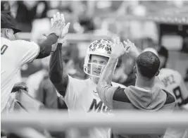  ?? DAVID SANTIAGO dsantiago@miamiheral­d.com ?? Designated hitter Garrett Cooper dons the Marlins’ celebrator­y football helmet after hitting a two-run home run during the third inning Wednesday.