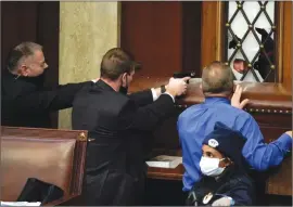  ?? The Associated Press ?? Police with guns drawn watch as protesters try to break into the House Chamber at the U.S. Capitol on Wednesday in Washington.