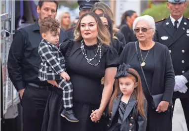  ?? PHOTOS BY MARK HENLE/THE REPUBLIC ?? Angela Madrid (center), widow of Mesa Fire Department Capt. Trevor Madrid, and her children, Mila (right) and Mav (left), look on as his casket arrives Tuesday at the Mission Church, 4450 E. Elliot Road in Mesa.